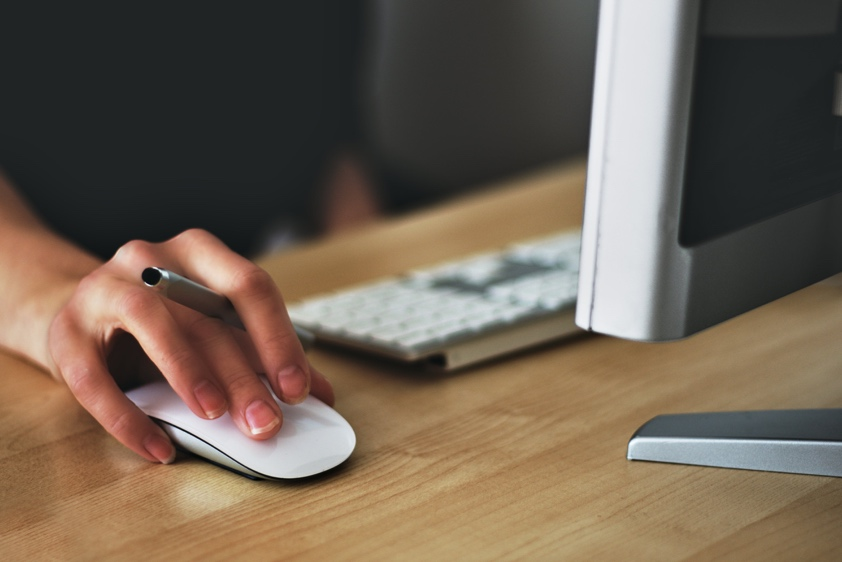 A person holding the Apple Magic Mouse