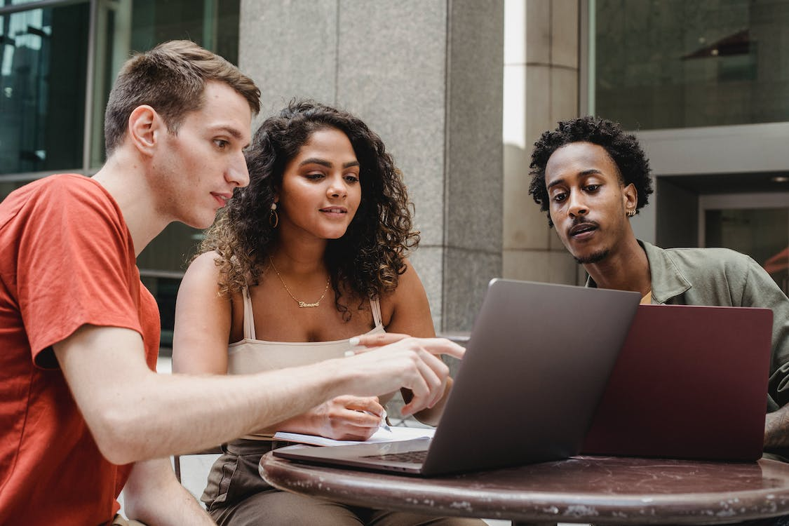 friends searching for alternative careers using a laptop