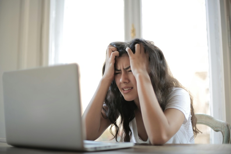 A woman in a white shirt showing frustration